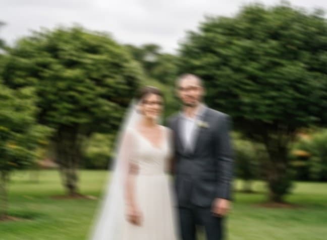 Casal no jardim com a foto tremida, marcada como reprovada